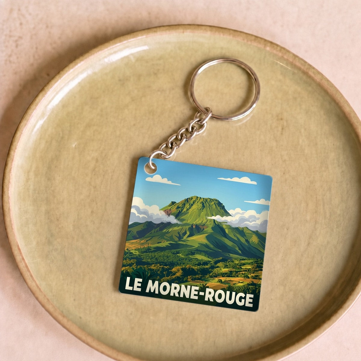 Porte-clés souvenir de la ville de Le Morne-Rouge avec une illustration stylisée d'un paysage de montagne.