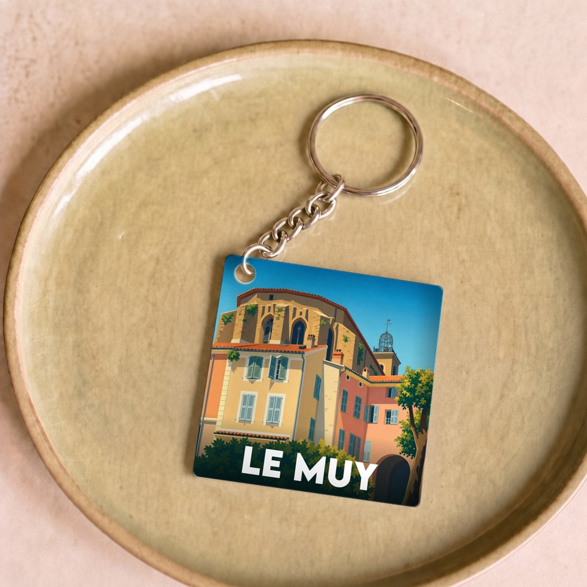 Porte-clés souvenir de la ville de Le Muy avec une illustration stylisée et colorée.