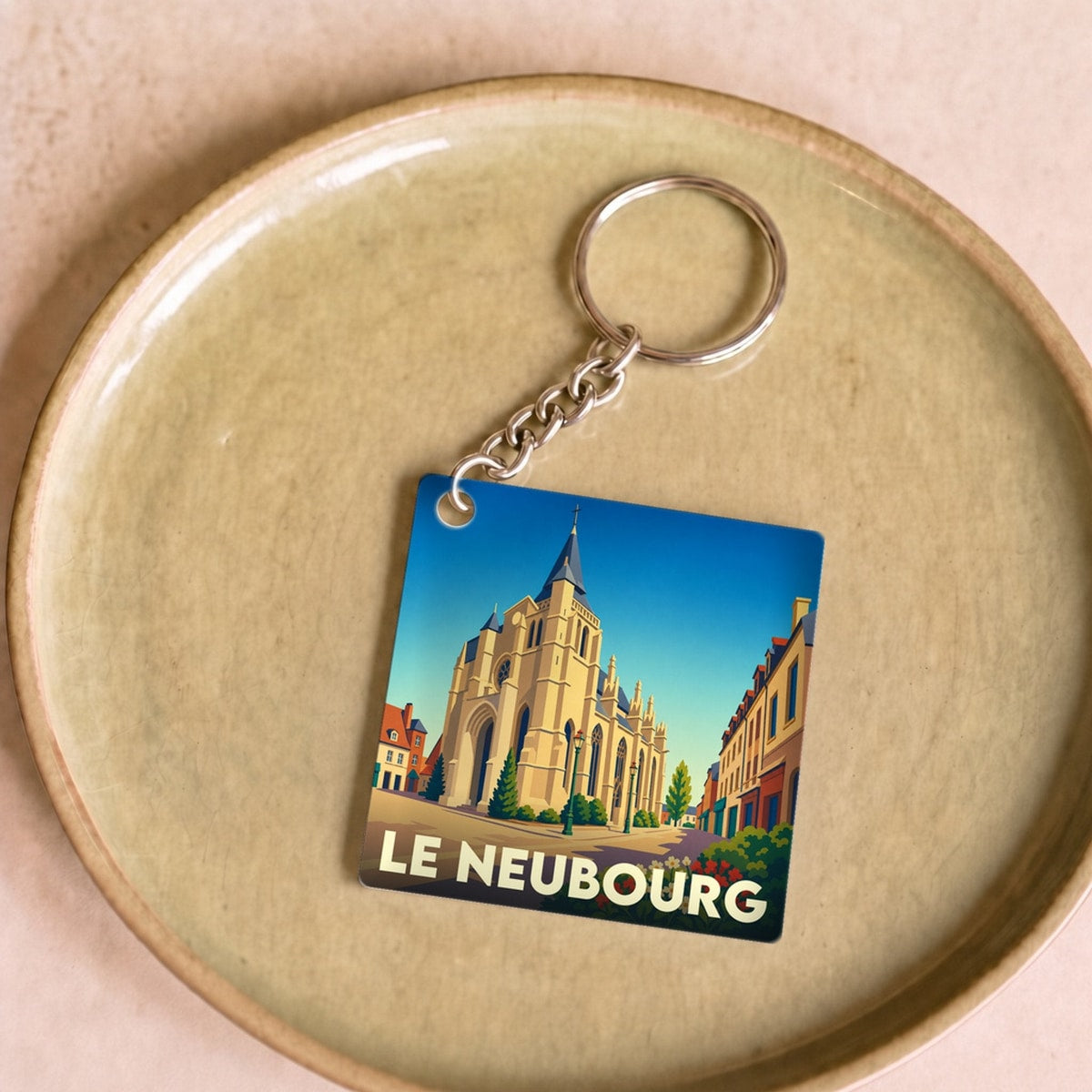 Porte-clés souvenir de la ville de Le Neubourg avec une illustration stylisée de son église.
