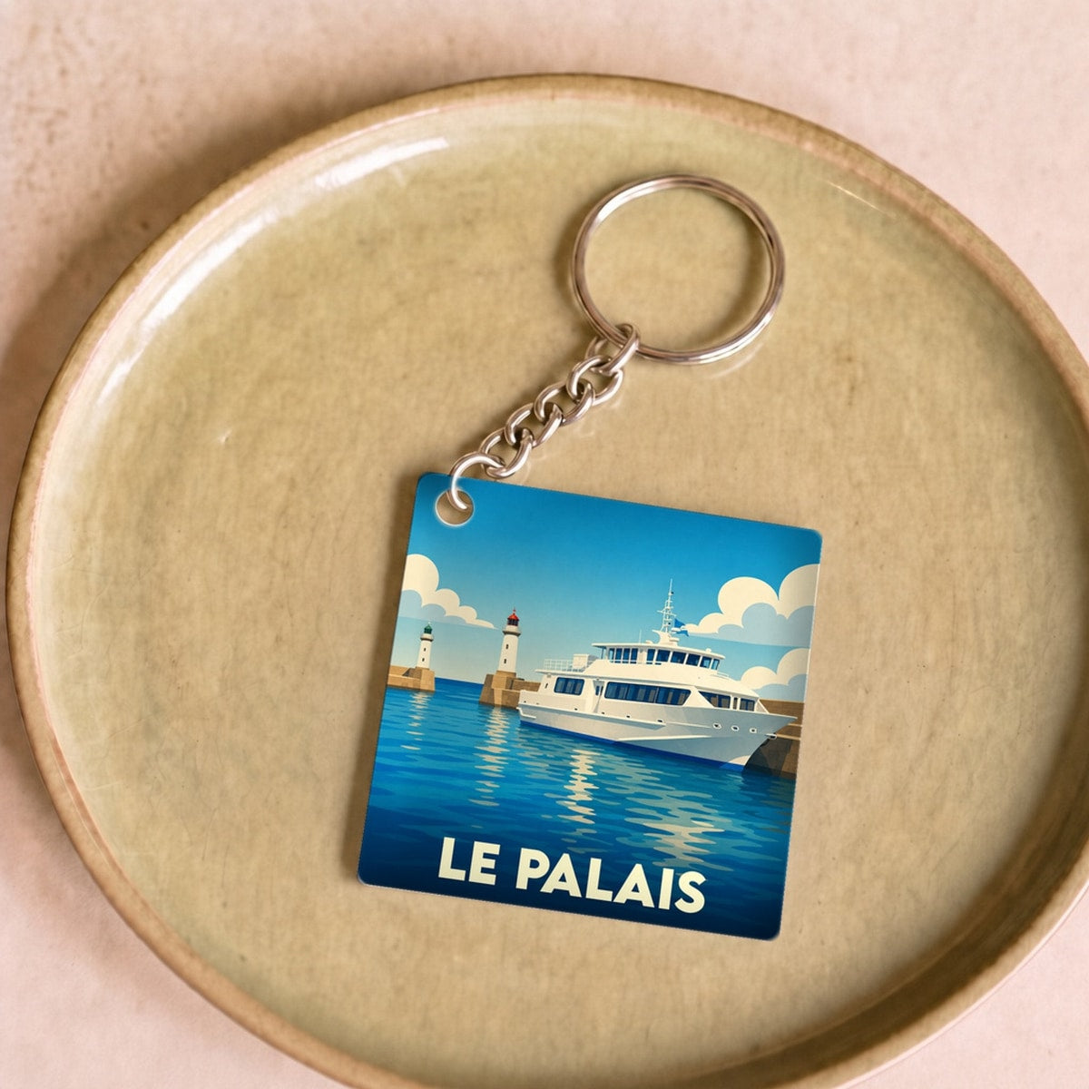 Porte-clés souvenir de la ville de Le Palais avec une illustration stylisée d'un bateau et d'un phare.