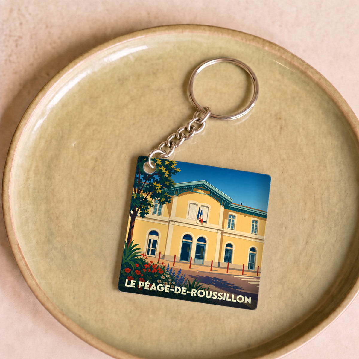 Porte-clés souvenir de la ville du Péage-de-Roussillon avec une illustration stylisée.