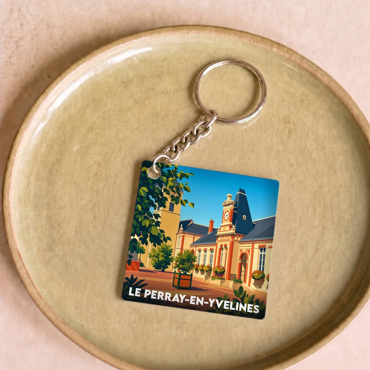 Porte-clés souvenir de la ville de Le Perray-en-Yvelines avec une illustration colorée et stylisée de l'hôtel de ville.