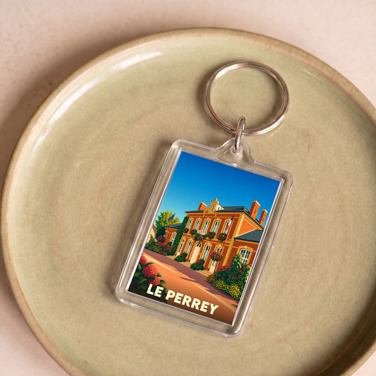 Porte-clés souvenir de la ville de Le Perrey avec une illustration stylisée.