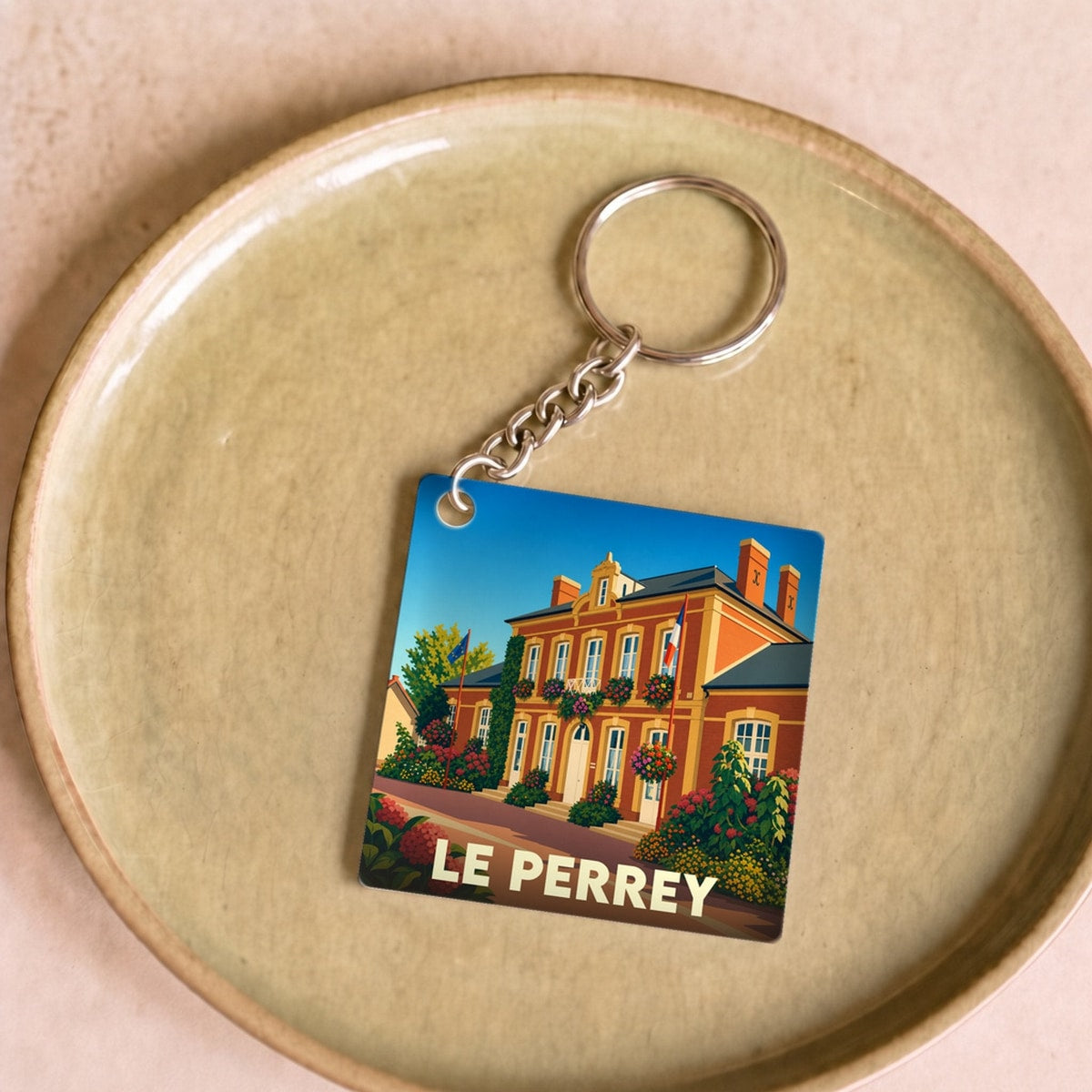Porte-clés souvenir de la ville de Le Perrey avec une illustration stylisée.