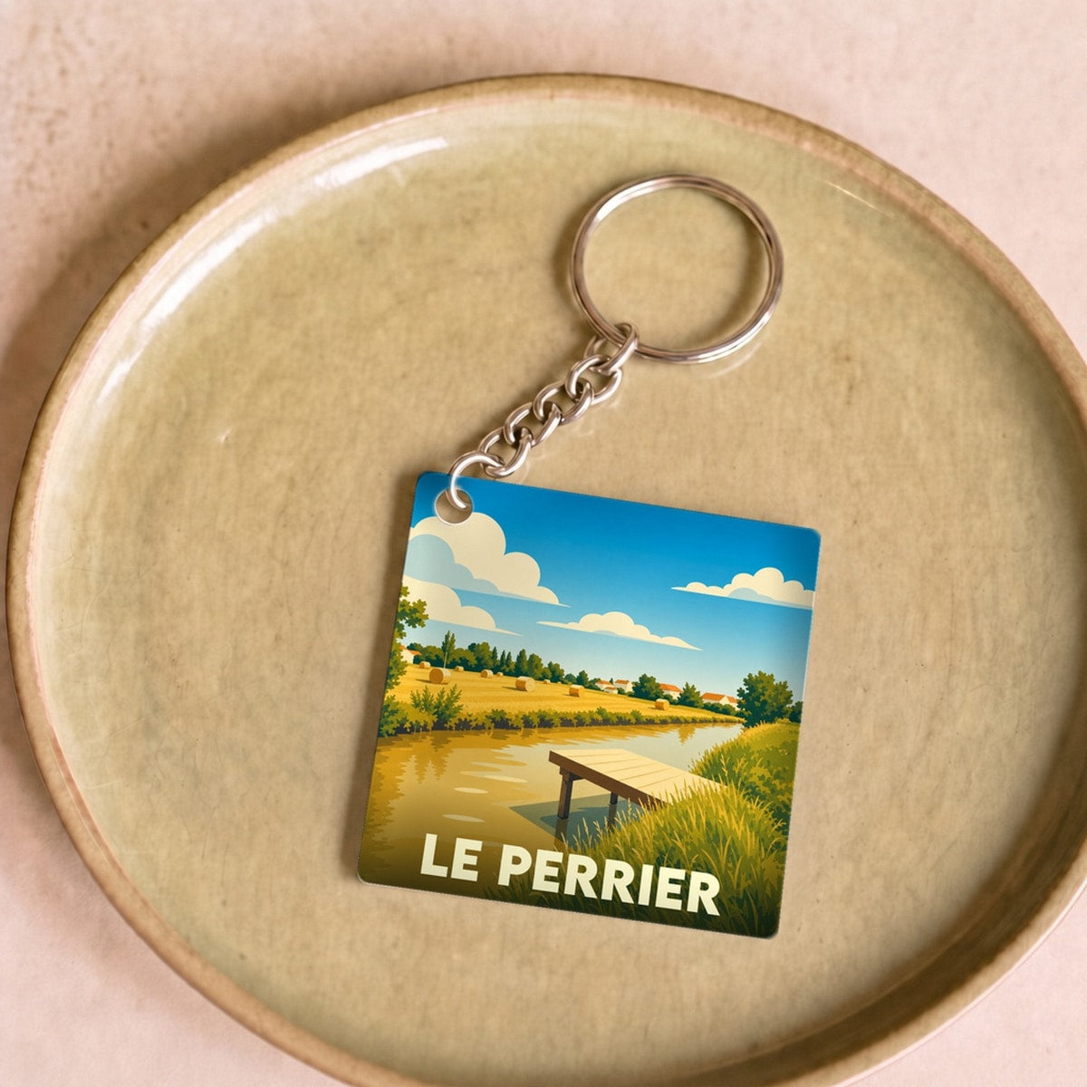 Porte-clés souvenir de la ville du Perrier avec une illustration stylisée de marais.