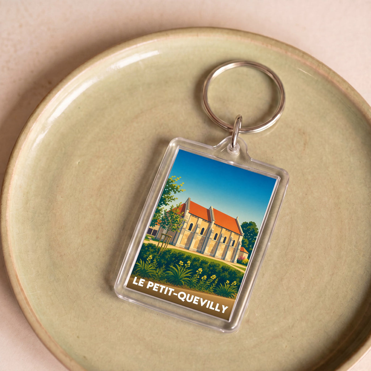 Porte-clés souvenir de la ville de Le Petit-Quevilly avec une illustration stylisée d'un monument historique.