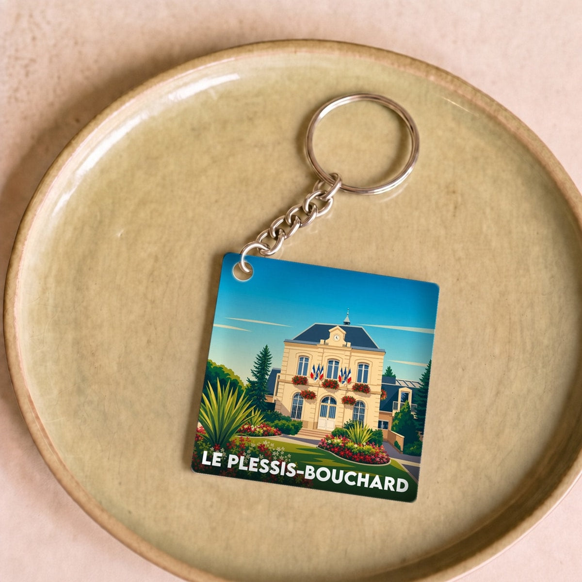 Porte-clés souvenir de la ville de Le Plessis-Bouchard avec une illustration stylisée de l'hôtel de ville.