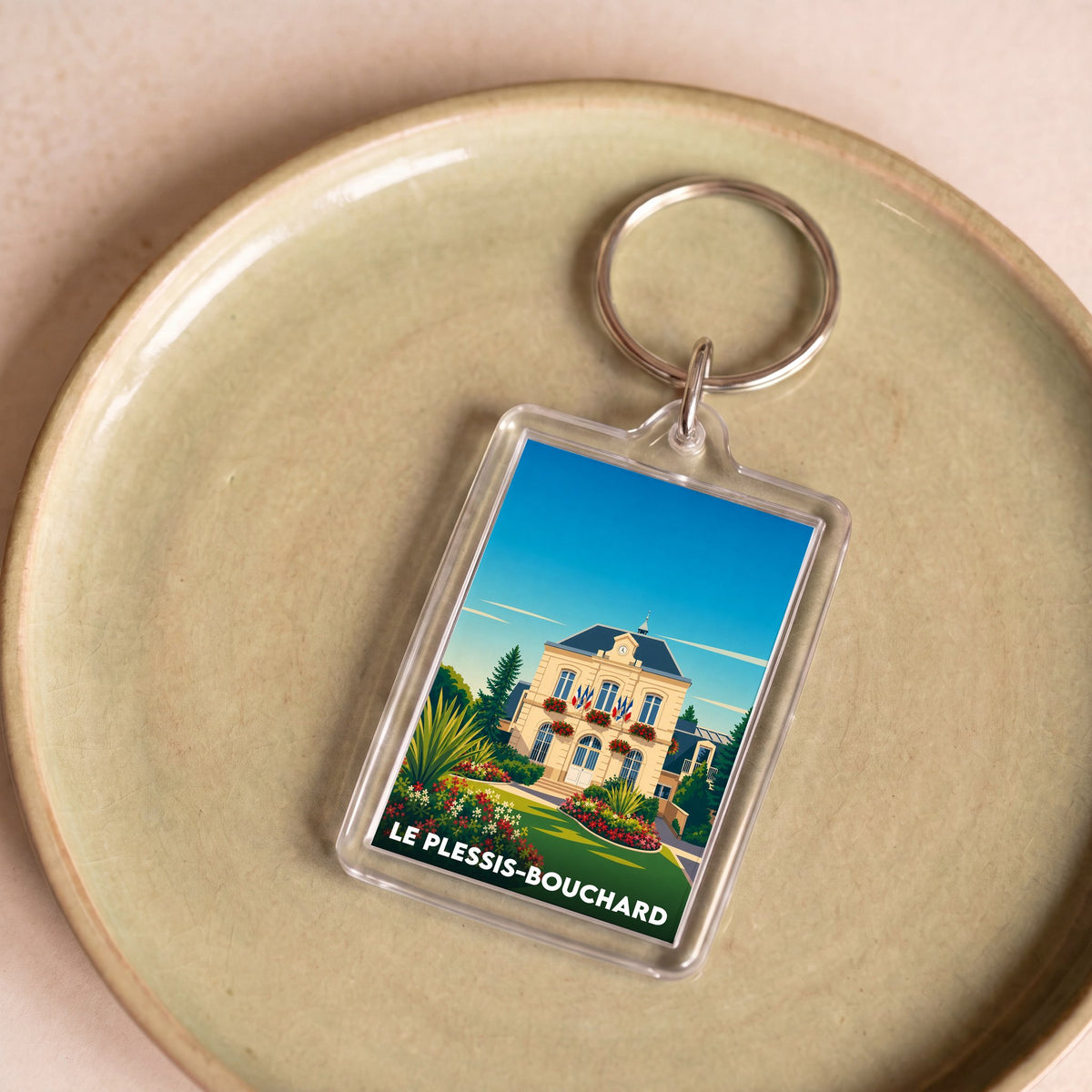 Porte-clés souvenir de la ville de Le Plessis-Bouchard avec une illustration stylisée de l'hôtel de ville.