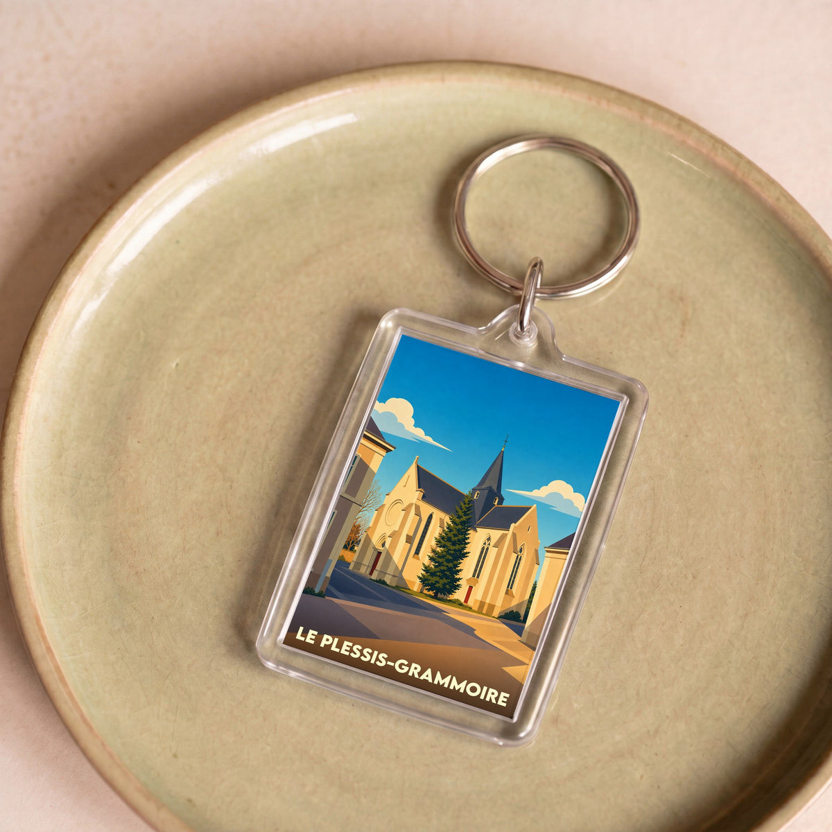 Porte-clés souvenir de la ville de Le Plessis-Grammoire avec une illustration stylisée de son église.