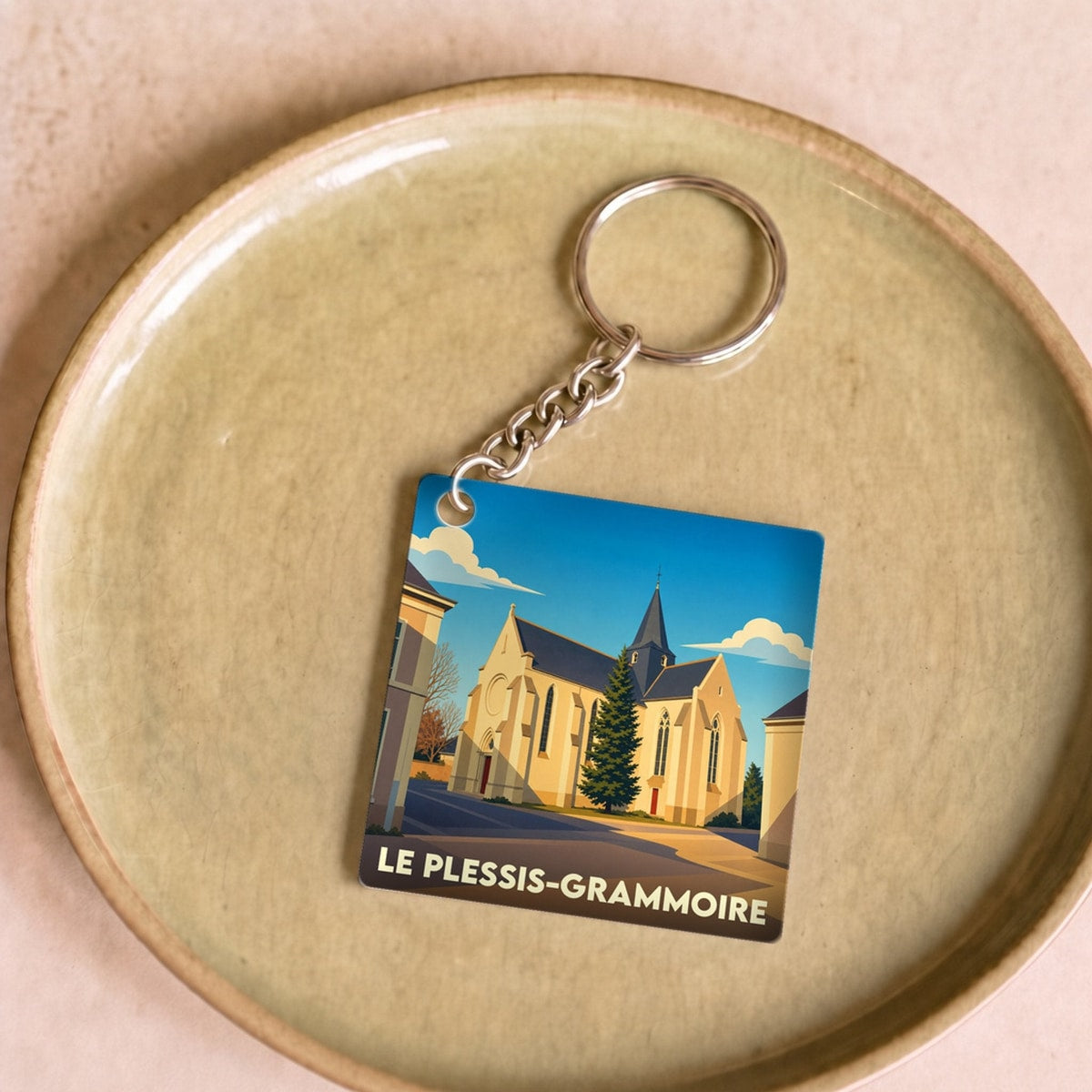 Porte-clés souvenir de la ville de Le Plessis-Grammoire avec une illustration stylisée de son église.