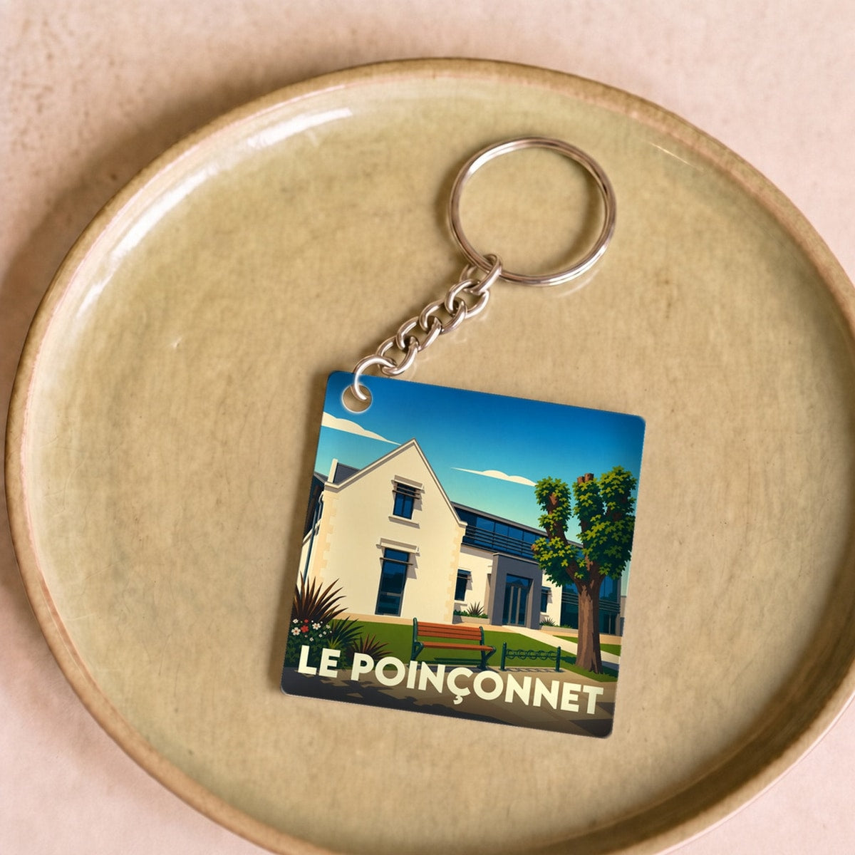 Porte-clés souvenir de la ville de Le Poinçonnet avec une illustration stylisée.