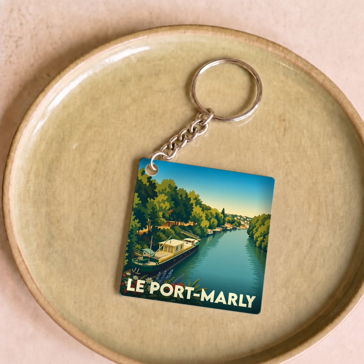 Porte-clés souvenir de la ville de Le Port-Marly avec une illustration stylisée d'une péniche sur la Seine.
