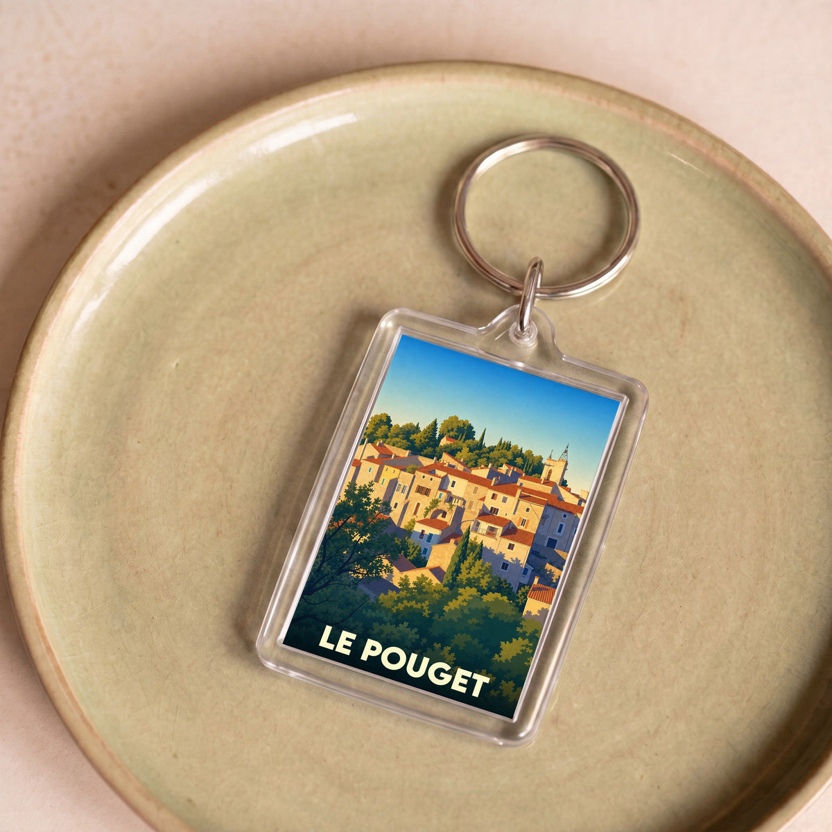 Porte-clés souvenir de la ville de Le Pouget avec une illustration stylisée.