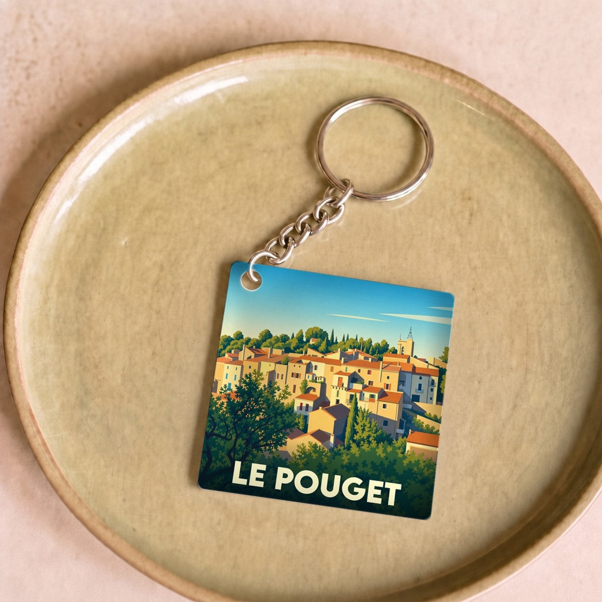 Porte-clés souvenir de la ville de Le Pouget avec une illustration stylisée.