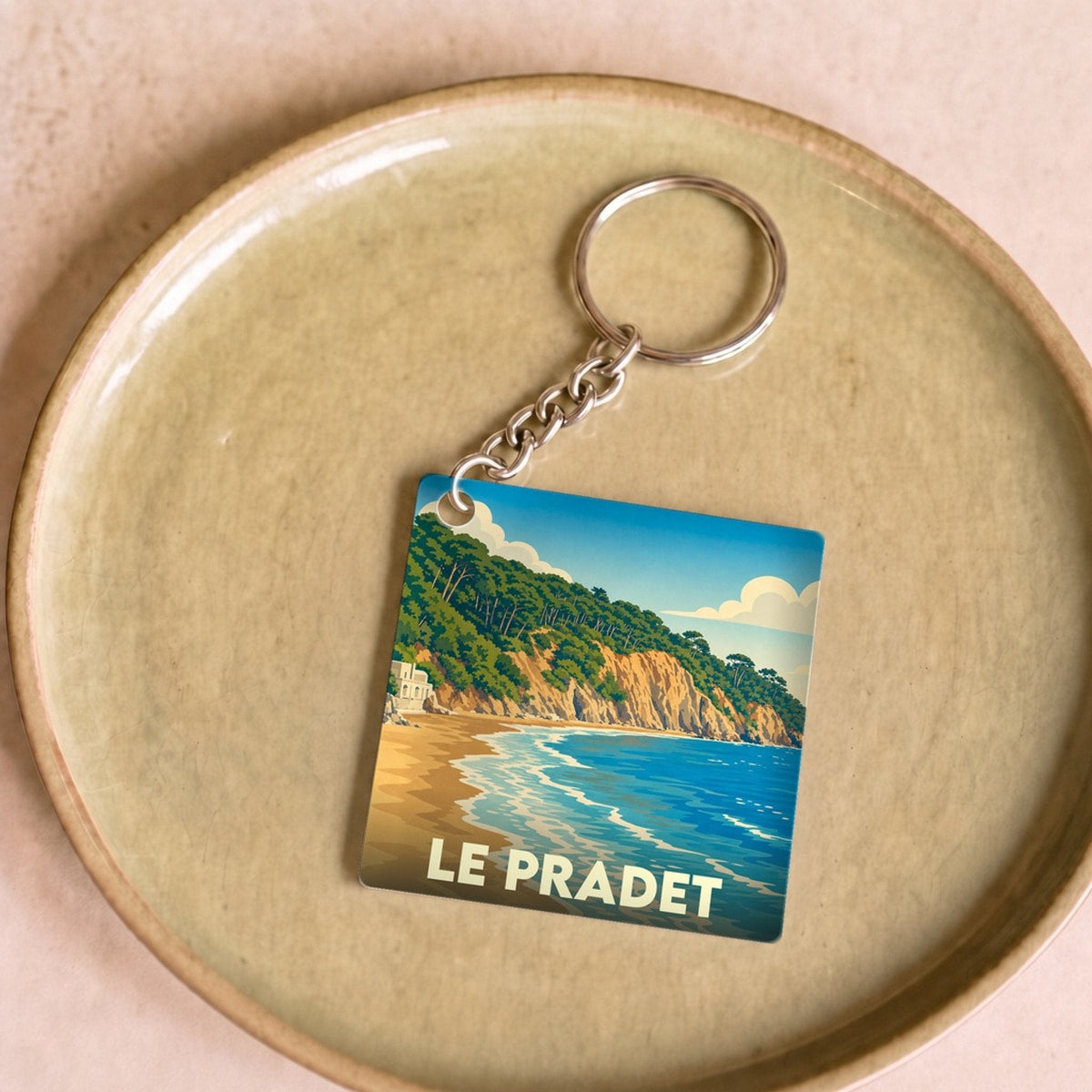 Porte-clés souvenir de la ville du Pradet avec une illustration stylisée de sa côte.