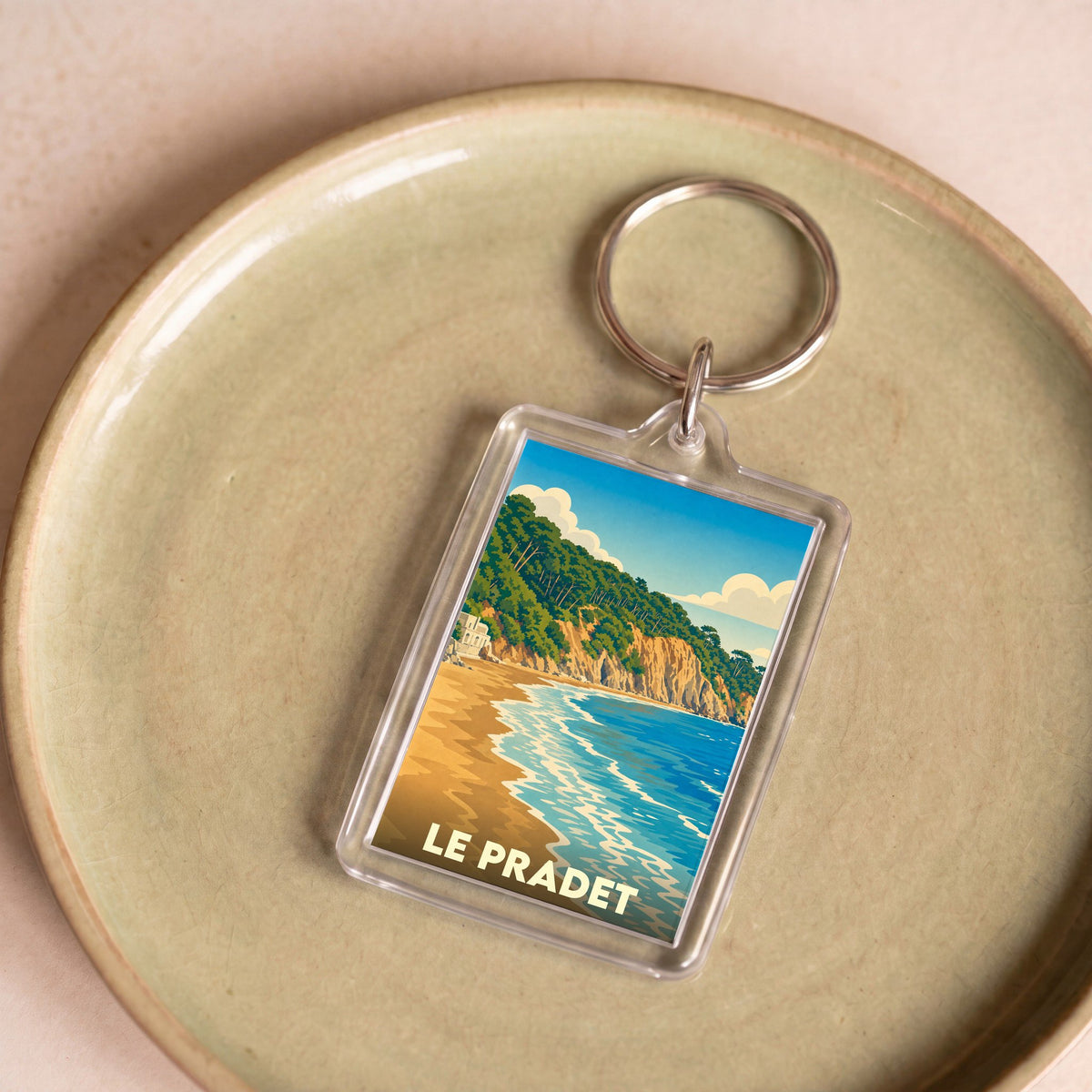 Porte-clés souvenir de la ville du Pradet avec une illustration stylisée de sa côte.