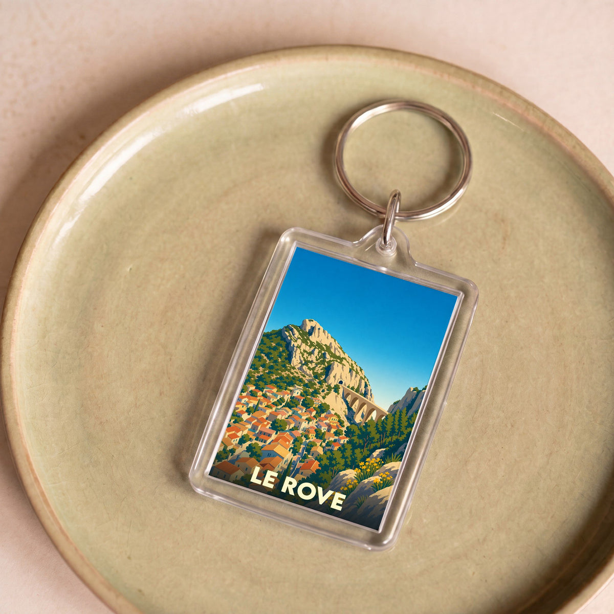 Porte-clés souvenir de la ville de Le Rove avec une illustration stylisée de son paysage provençal.