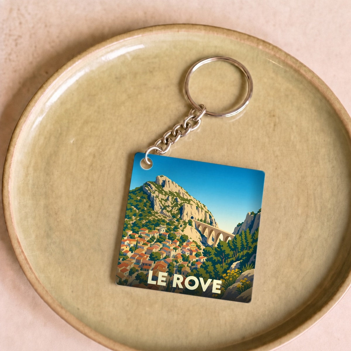 Porte-clés souvenir de la ville de Le Rove avec une illustration stylisée de son paysage provençal.