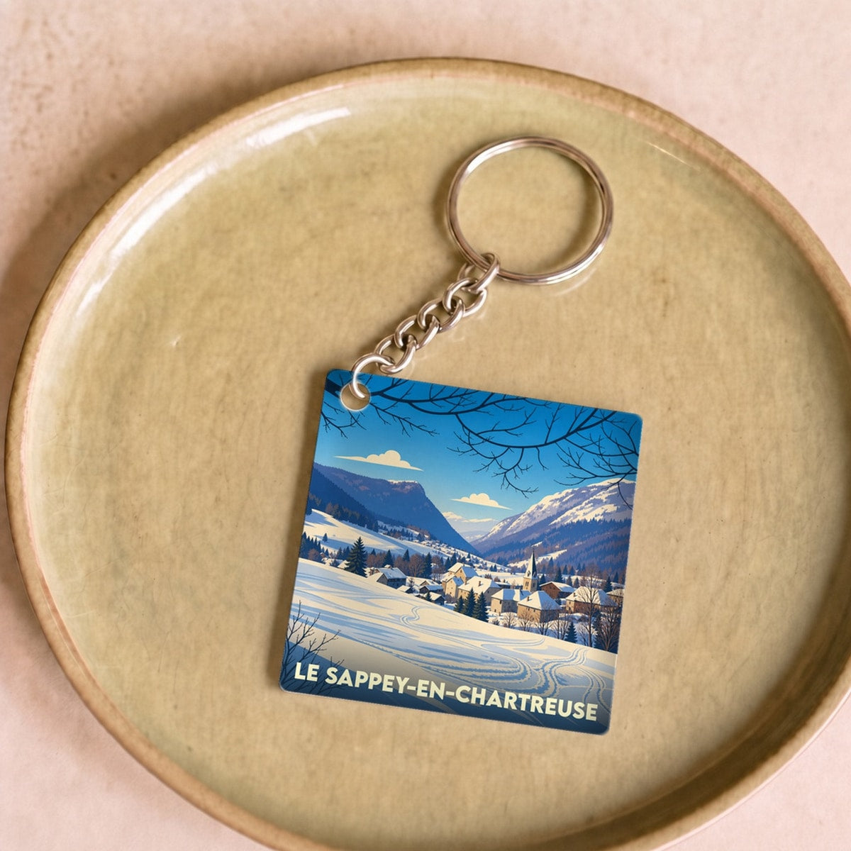 Porte-clés souvenir de la commune de Le Sappey-en-Chartreuse avec une illustration hivernale stylisée.