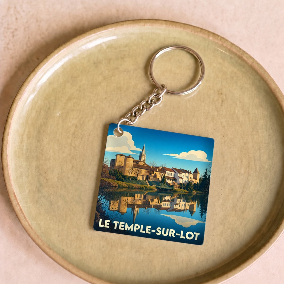 Porte-clés souvenir de la ville du Temple-sur-Lot avec une illustration stylisée.