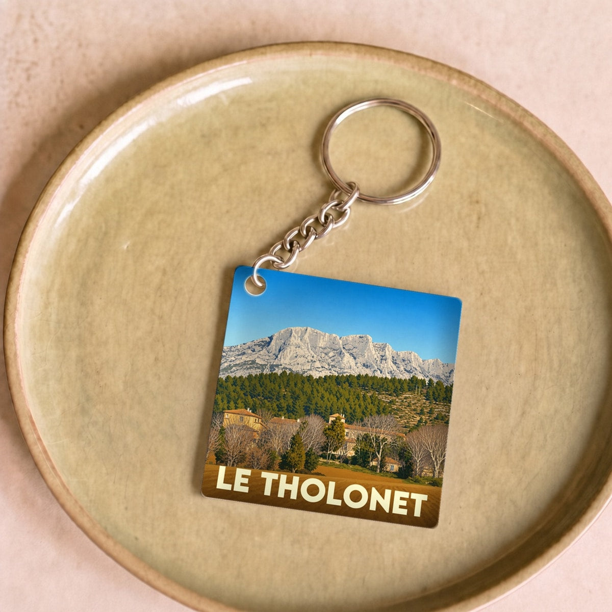 Porte-clés souvenir de la ville de Le Tholonet avec une illustration de la montagne Sainte-Victoire.