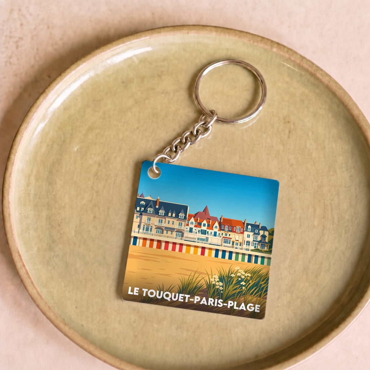 Porte-clés souvenir de la ville de Le Touquet-Paris-Plage avec une illustration stylisée de son front de mer.