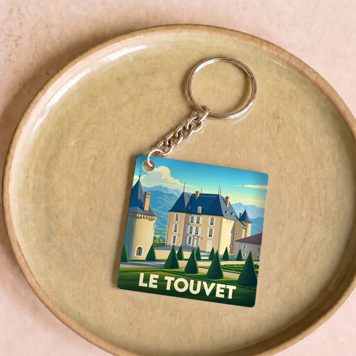 Porte-clés souvenir de la ville du Touvet avec une illustration stylisée de son château.