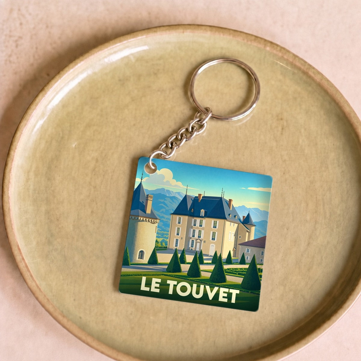 Porte-clés souvenir de la ville du Touvet avec une illustration stylisée de son château.