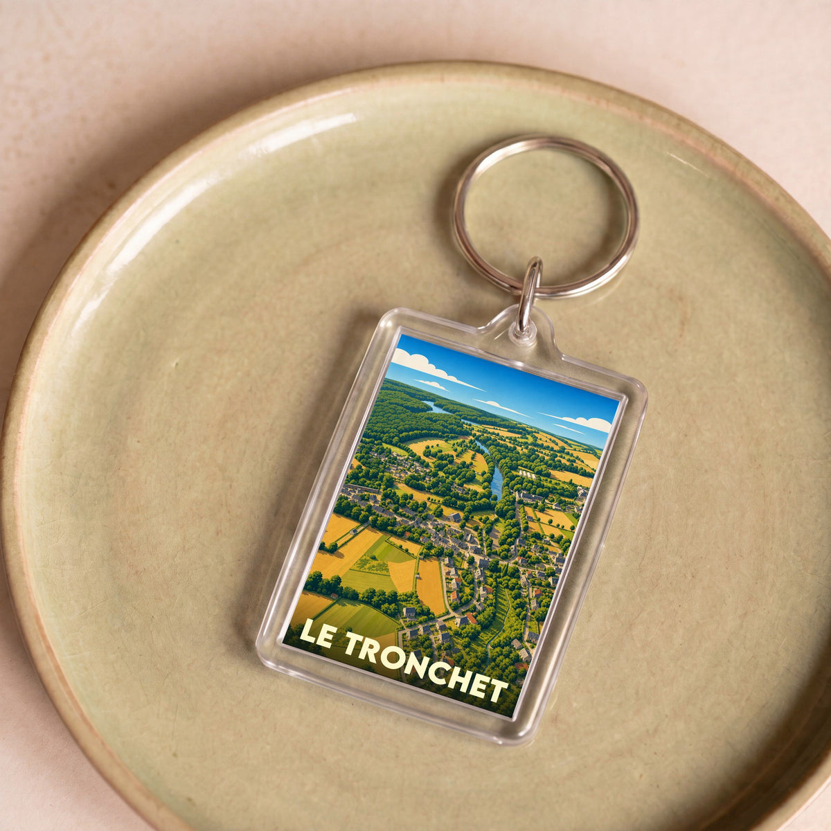 Porte-clés souvenir de la ville de Le Tronchet avec une illustration stylisée vue du ciel.