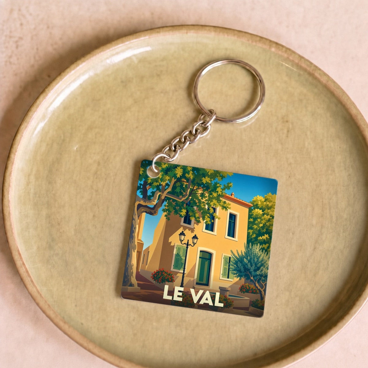 Porte-clés souvenir de la ville de Le Val avec une illustration stylisée d'une maison provençale.