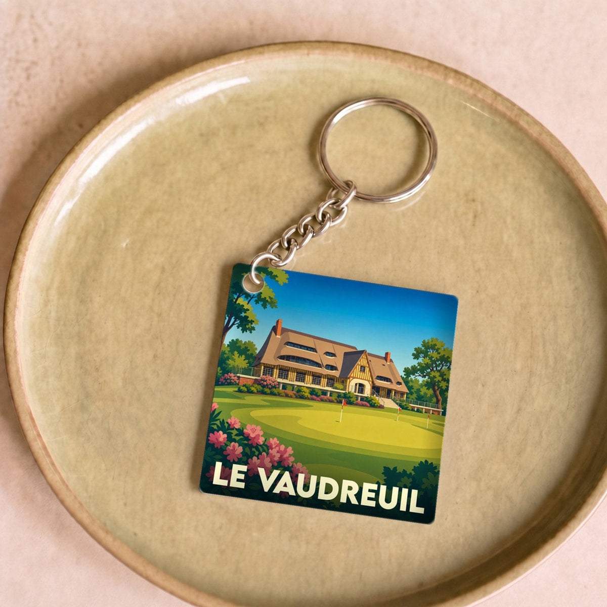 Porte-clés souvenir de la ville de Le Vaudreuil avec une illustration stylisée de son golf.