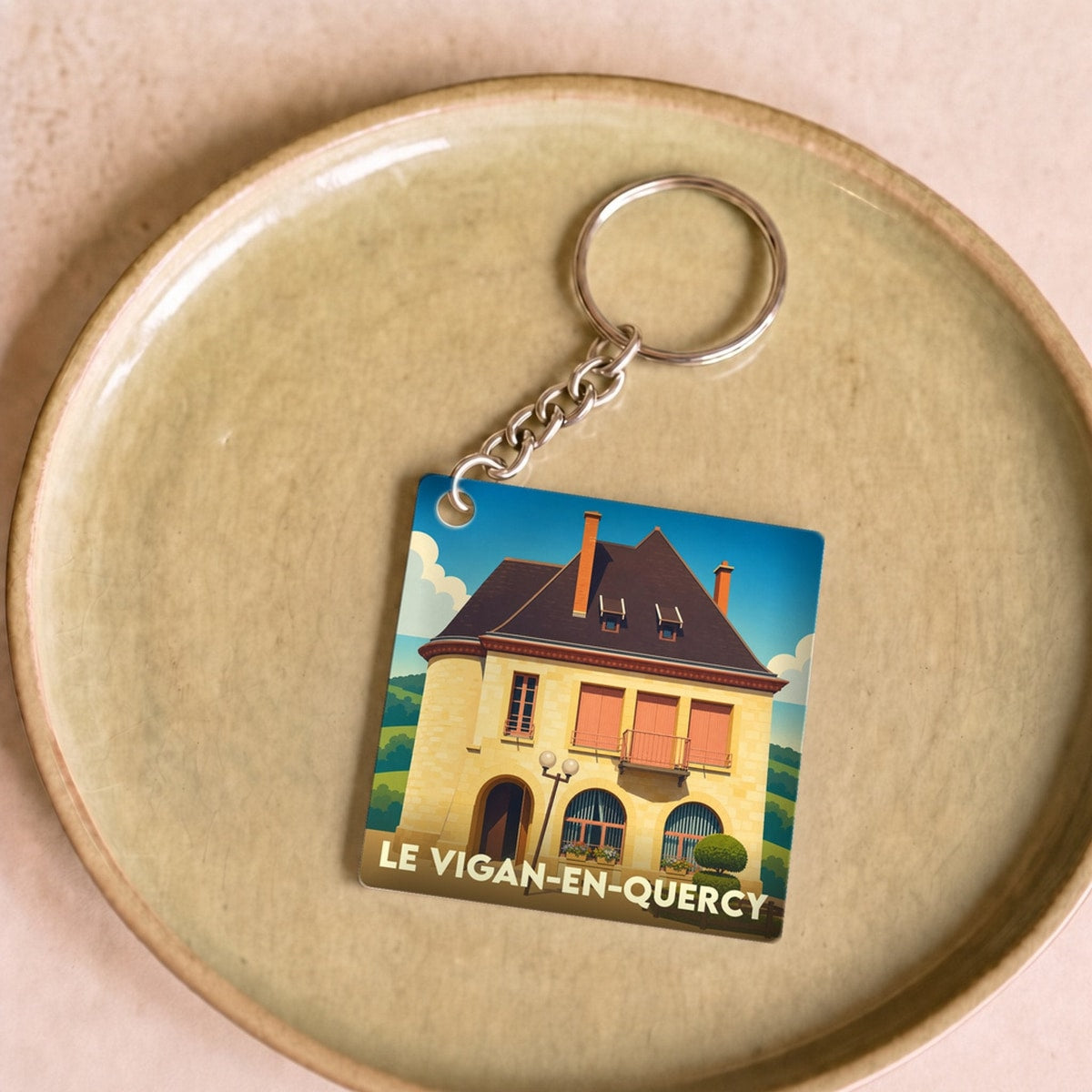 Porte-clés souvenir de la ville de Le Vigan-en-Quercy avec une illustration stylisée.