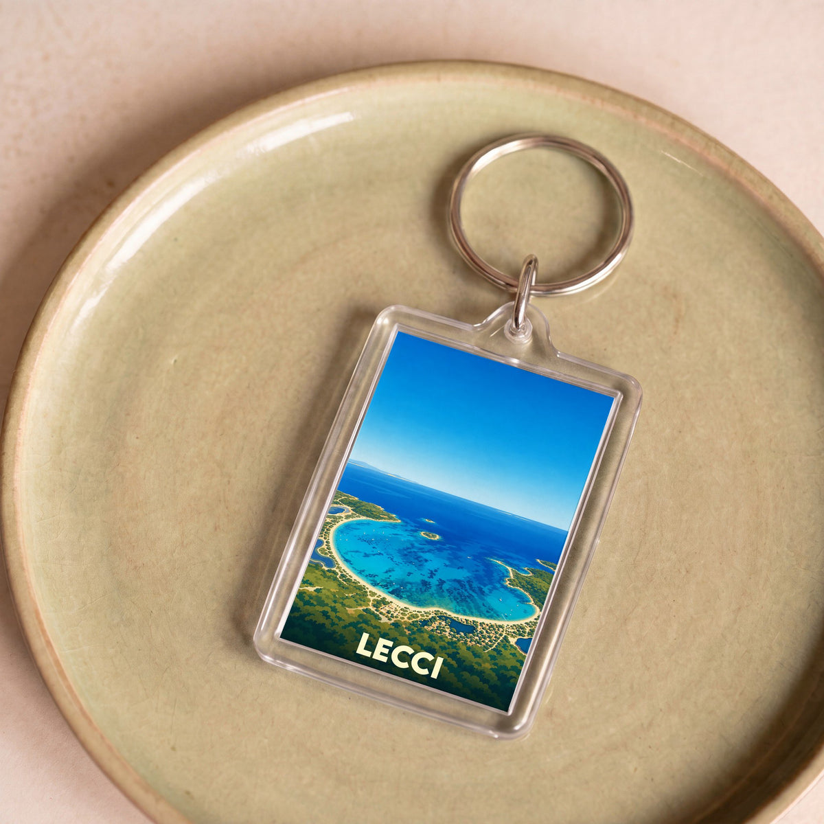 Porte-clés souvenir de la commune de Lecci arborant une illustration stylisée de son littoral.