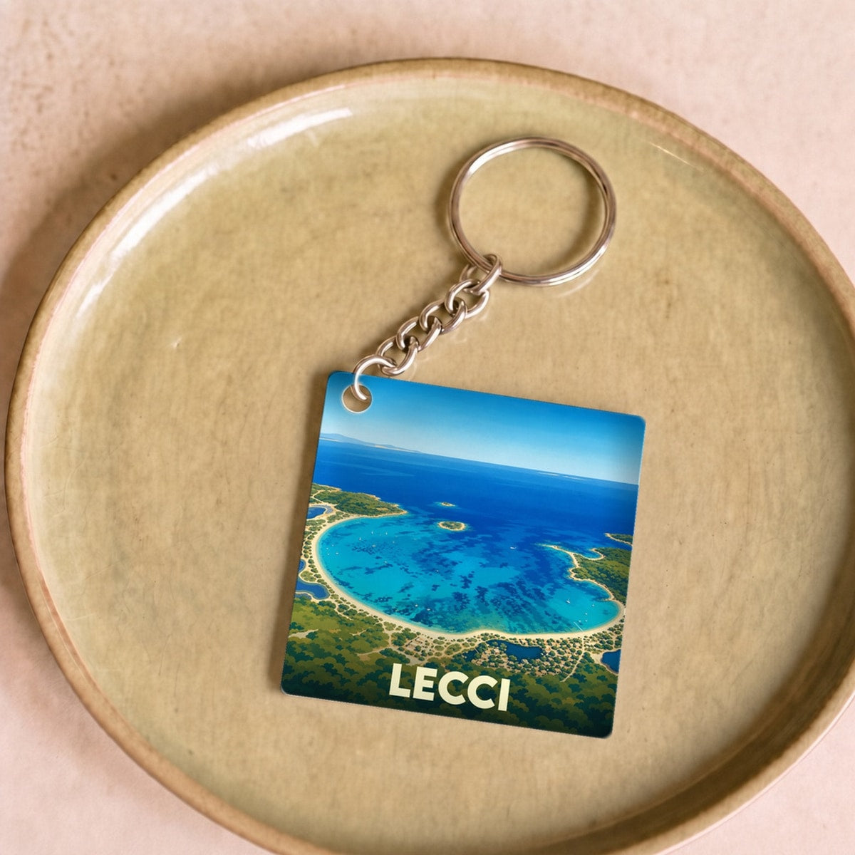 Porte-clés souvenir de la commune de Lecci arborant une illustration stylisée de son littoral.