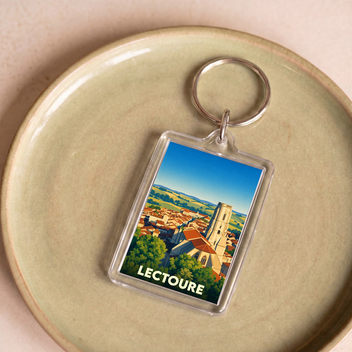 Porte-clés souvenir de la ville de Lectoure avec une illustration stylisée de ses toits et de sa cathédrale.
