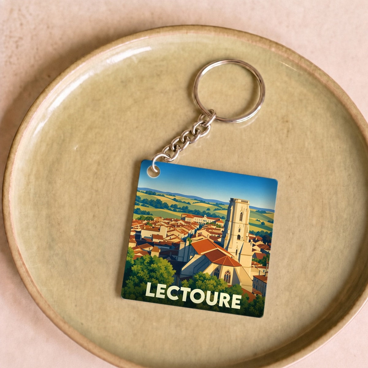 Porte-clés souvenir de la ville de Lectoure avec une illustration stylisée de ses toits et de sa cathédrale.