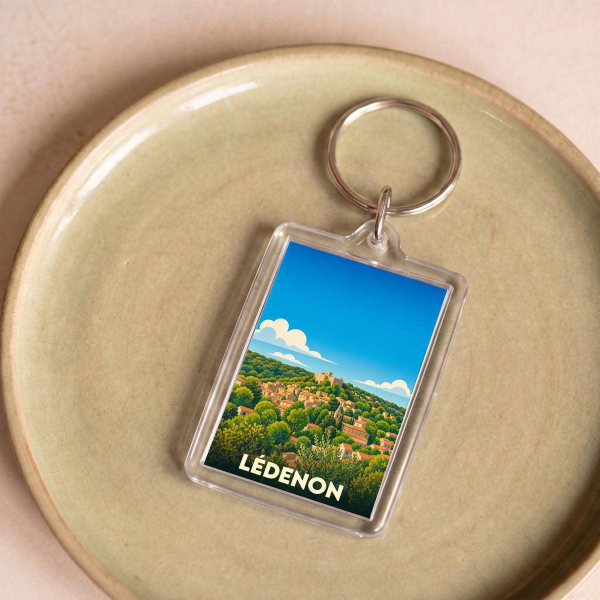 Porte-clés souvenir de la ville de Lédenon avec une illustration stylisée.