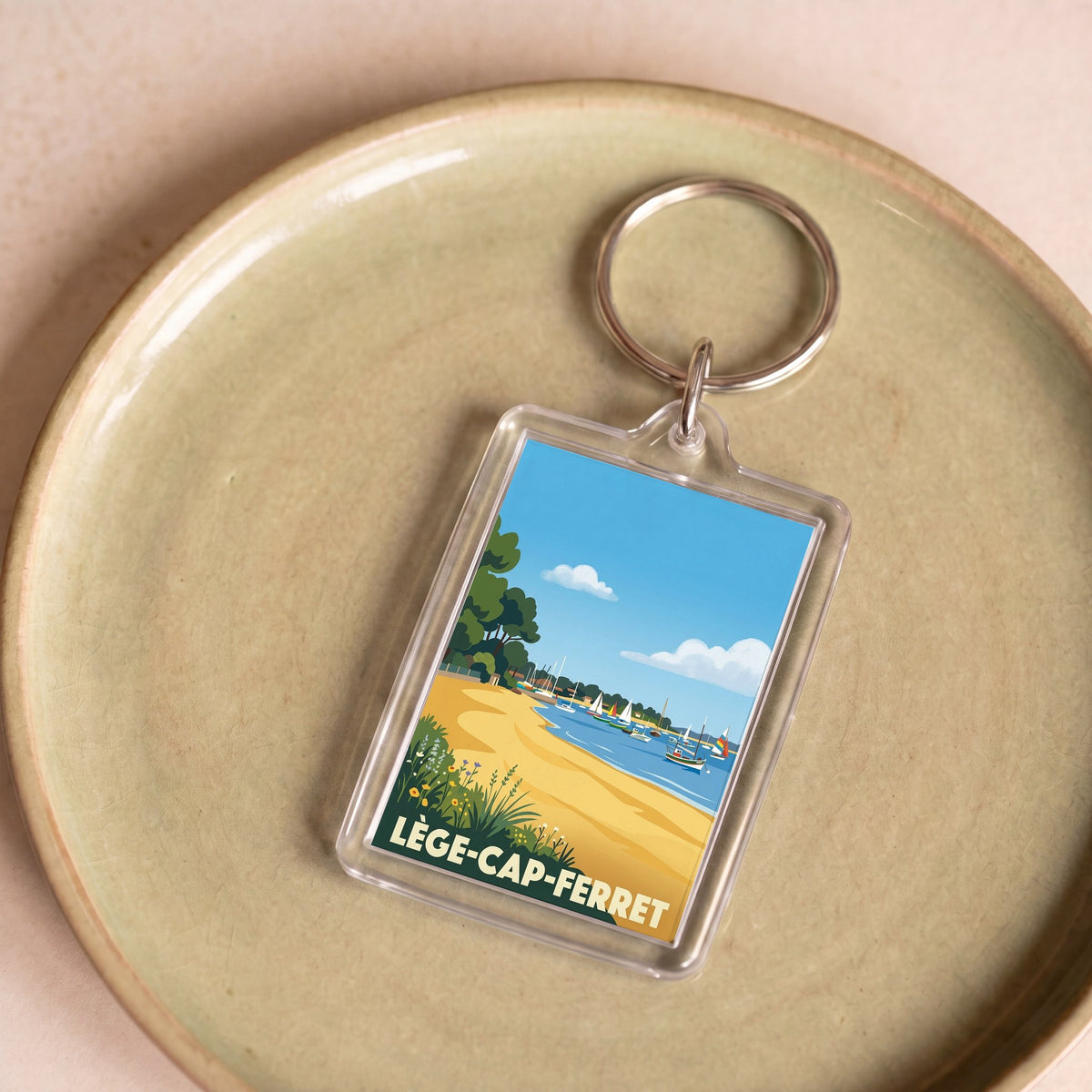 Porte-clés souvenir de la ville de Lège-Cap-Ferret avec une illustration stylisée.