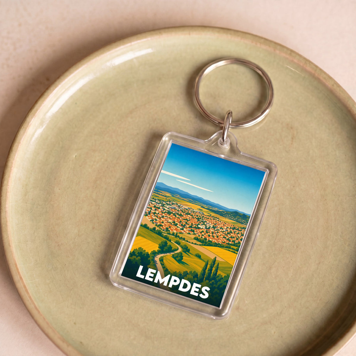 Porte-clés souvenir de la ville de Lempdes avec une illustration stylisée.