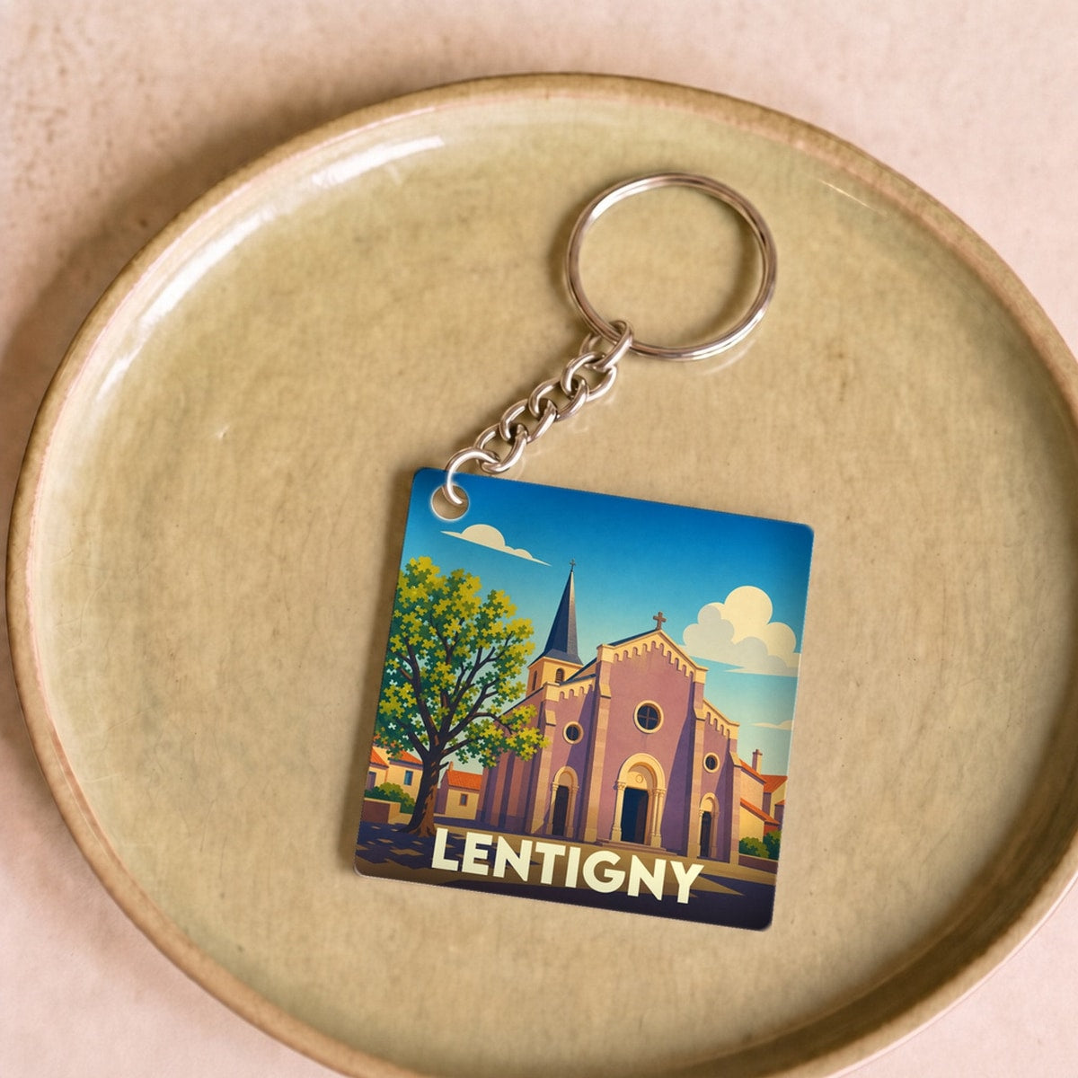 Porte-clés souvenir de la ville de Lentigny avec une illustration stylisée de son église.