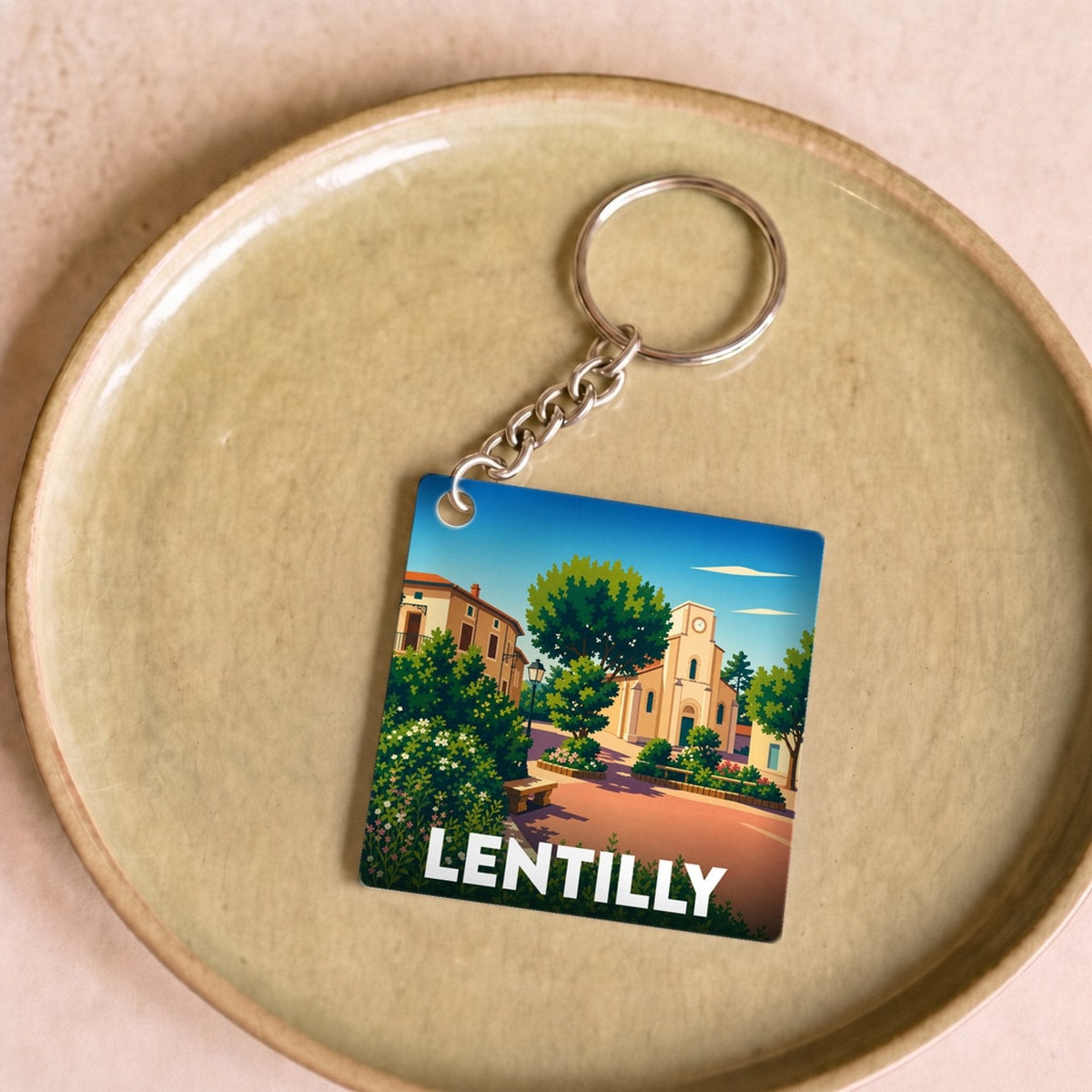 Porte-clés souvenir de la ville de Lentilly avec une illustration stylisée.