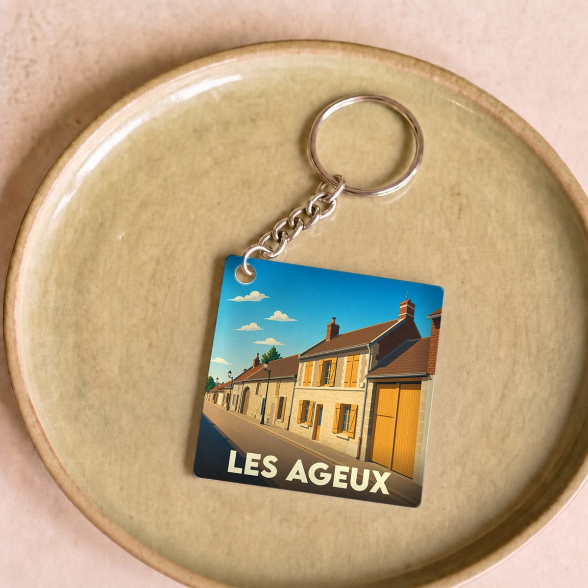 Porte-clés souvenir de la ville de Les Ageux avec une illustration stylisée.