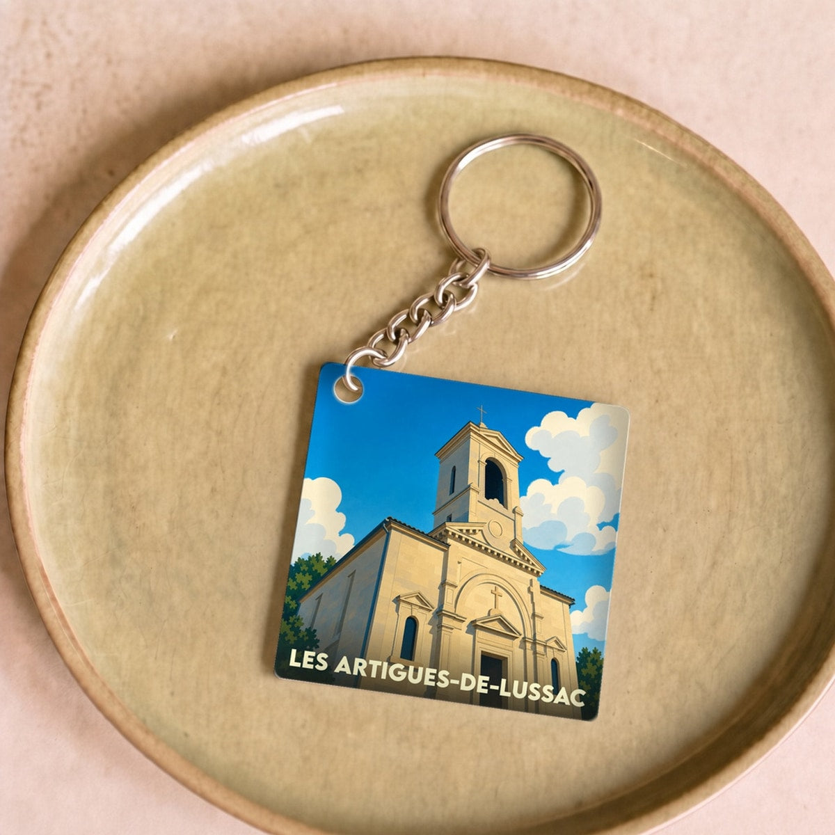 Porte-clés souvenir de la ville de Les Artigues-de-Lussac avec une illustration stylisée de son église.