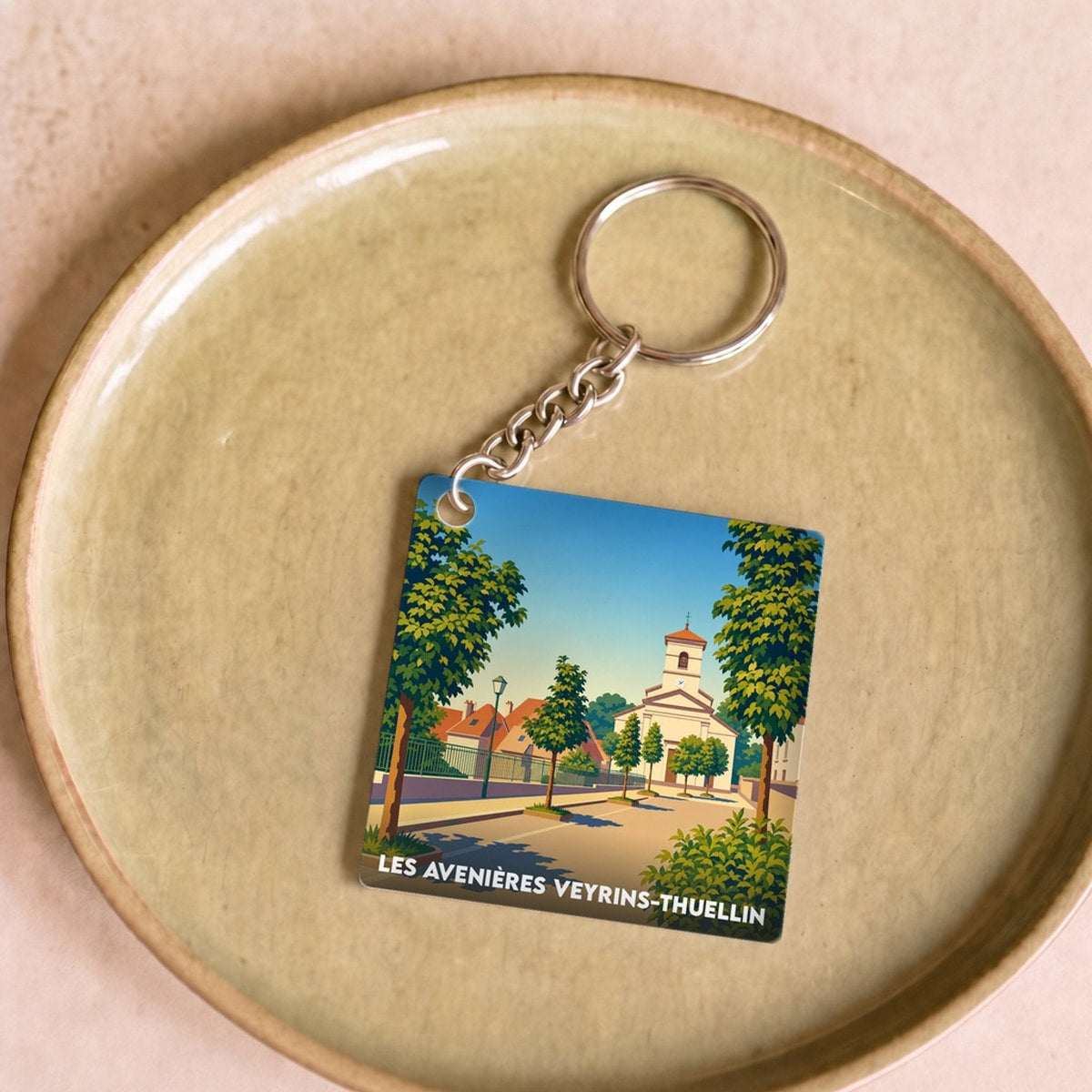Porte-clés souvenir de la ville de Les Avenières Veyrins-Thuellin avec une illustration stylisée.