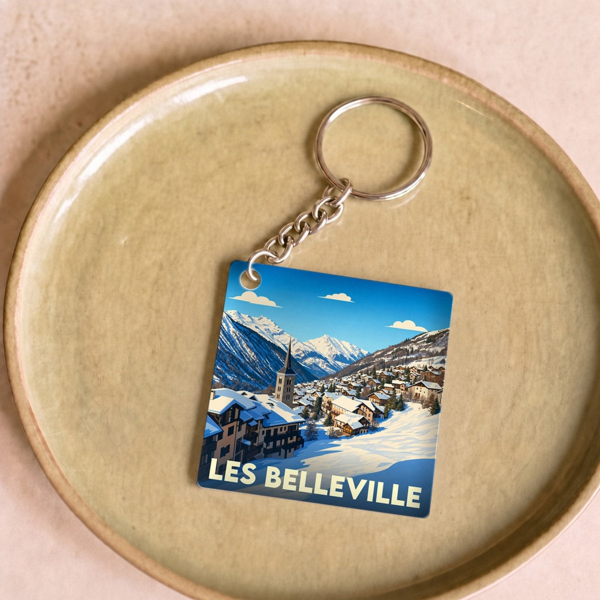Porte-clés souvenir de la ville de Les Belleville avec une illustration hivernale stylisée.