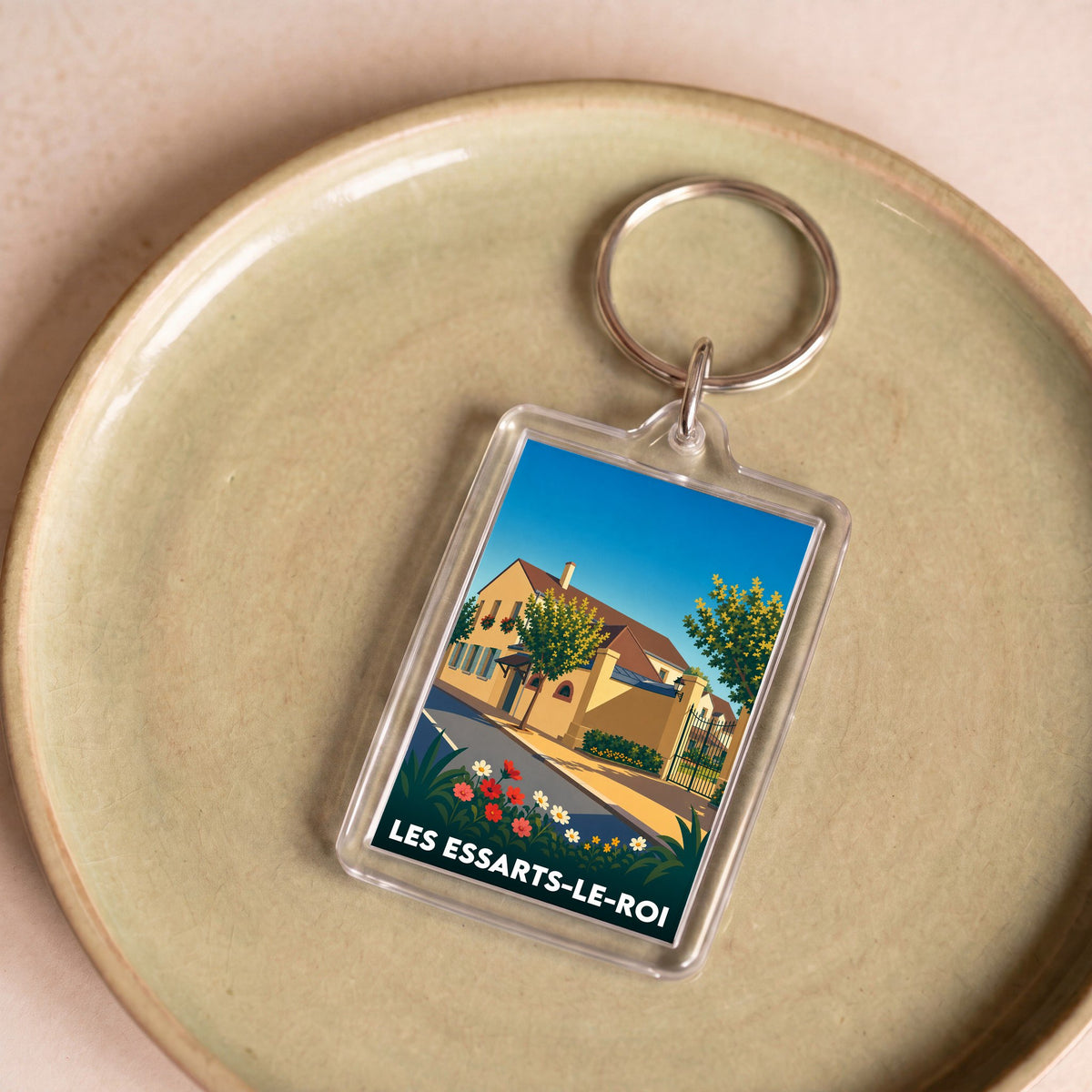 Porte-clés souvenir de la ville de Les Essarts-le-Roi avec une illustration stylisée d'une maison ensoleillée.