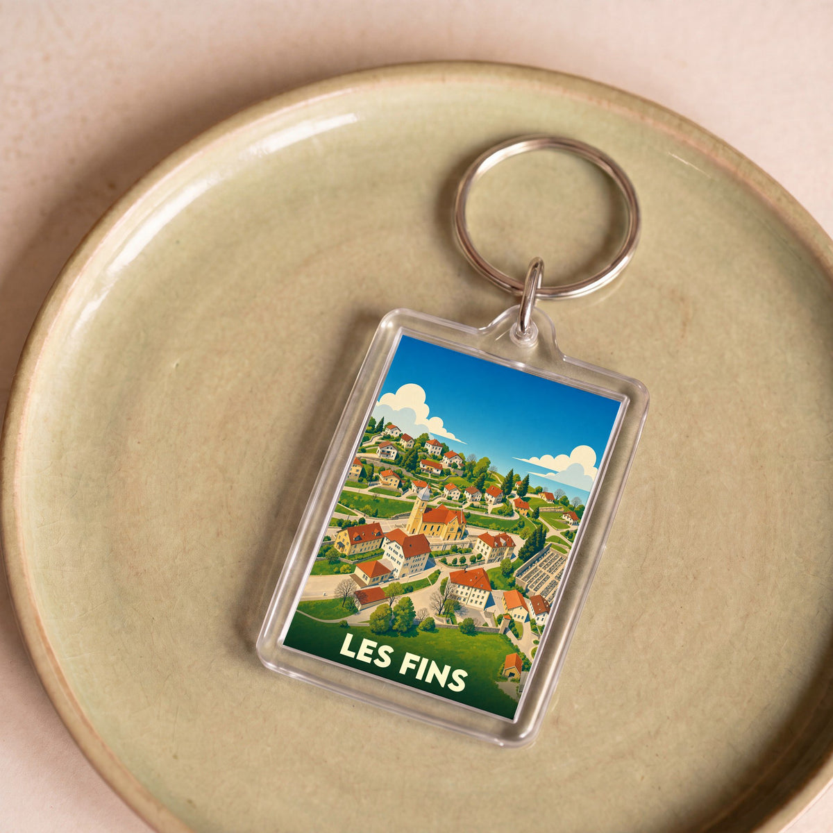 Porte-clés souvenir de la ville de Les Fins avec une illustration stylisée.
