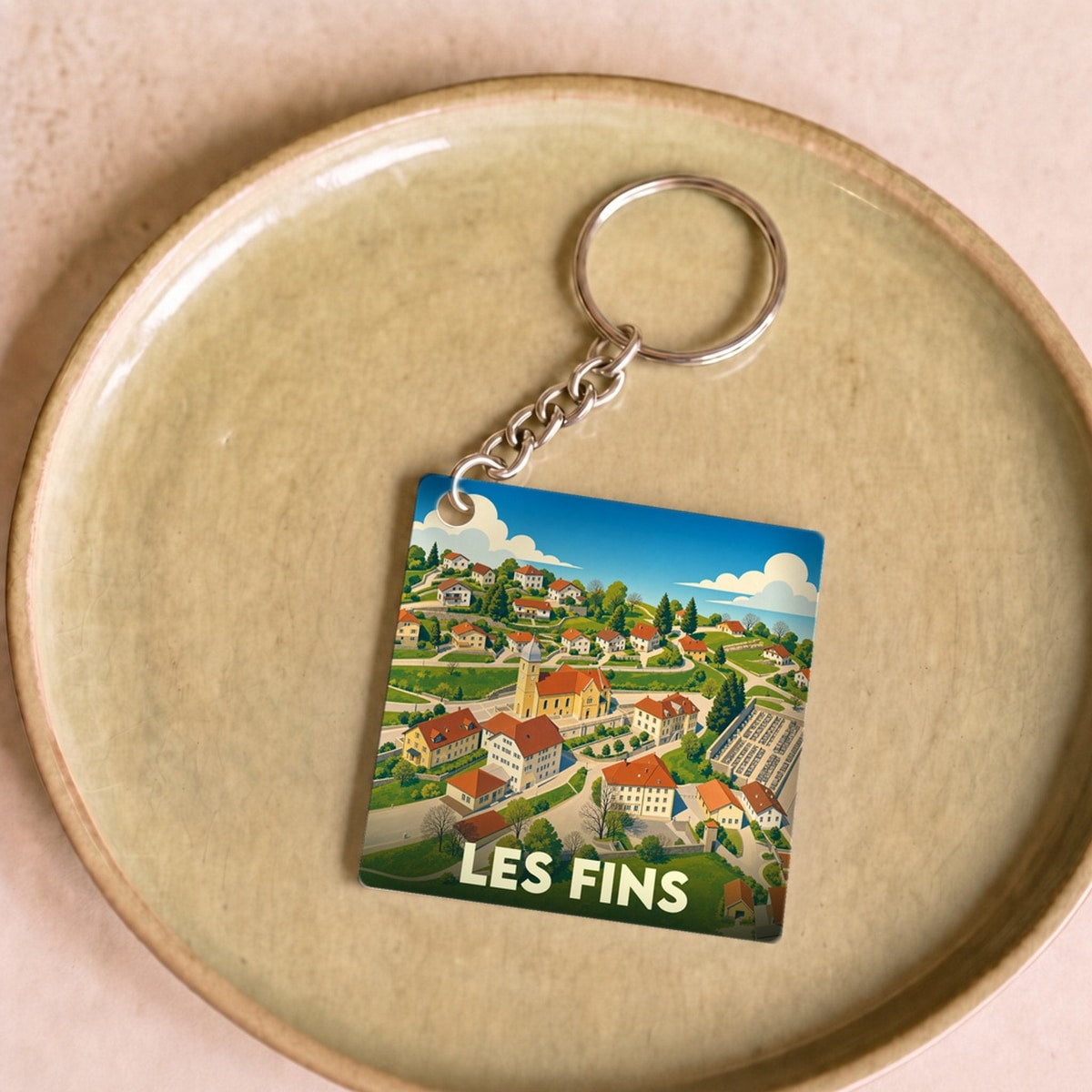 Porte-clés souvenir de la ville de Les Fins avec une illustration stylisée.