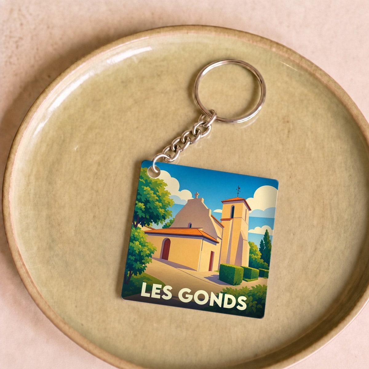 Porte-clés souvenir de la ville de Les Gonds avec une illustration stylisée de son église.