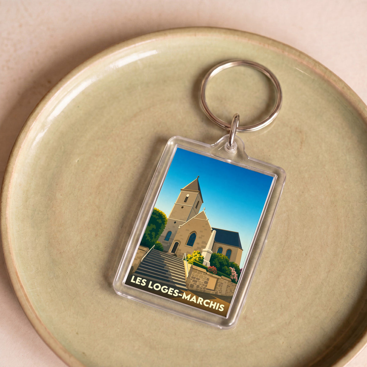 Porte-clés souvenir de la ville de Les Loges-Marchis avec une illustration stylisée de son église.